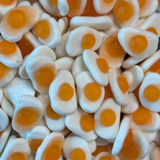 Close-up of small white and orange egg-shaped jelly candies.